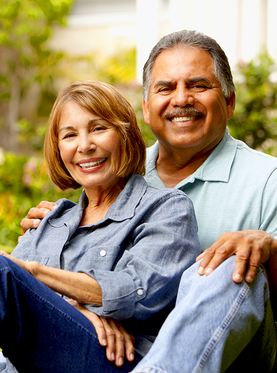 Smiling couple sitting outside.